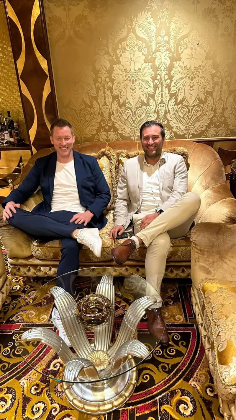 Heiko Wulf und Artur Haase sitzen nebeneinander auf einem goldenen Sofa in einer Casino-Lounge.