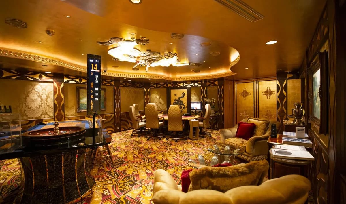 Vergoldeter VIP-Raum im King's Casino Rozvadov mit Roulettetisch, Pokertisch und Sitzgruppe.