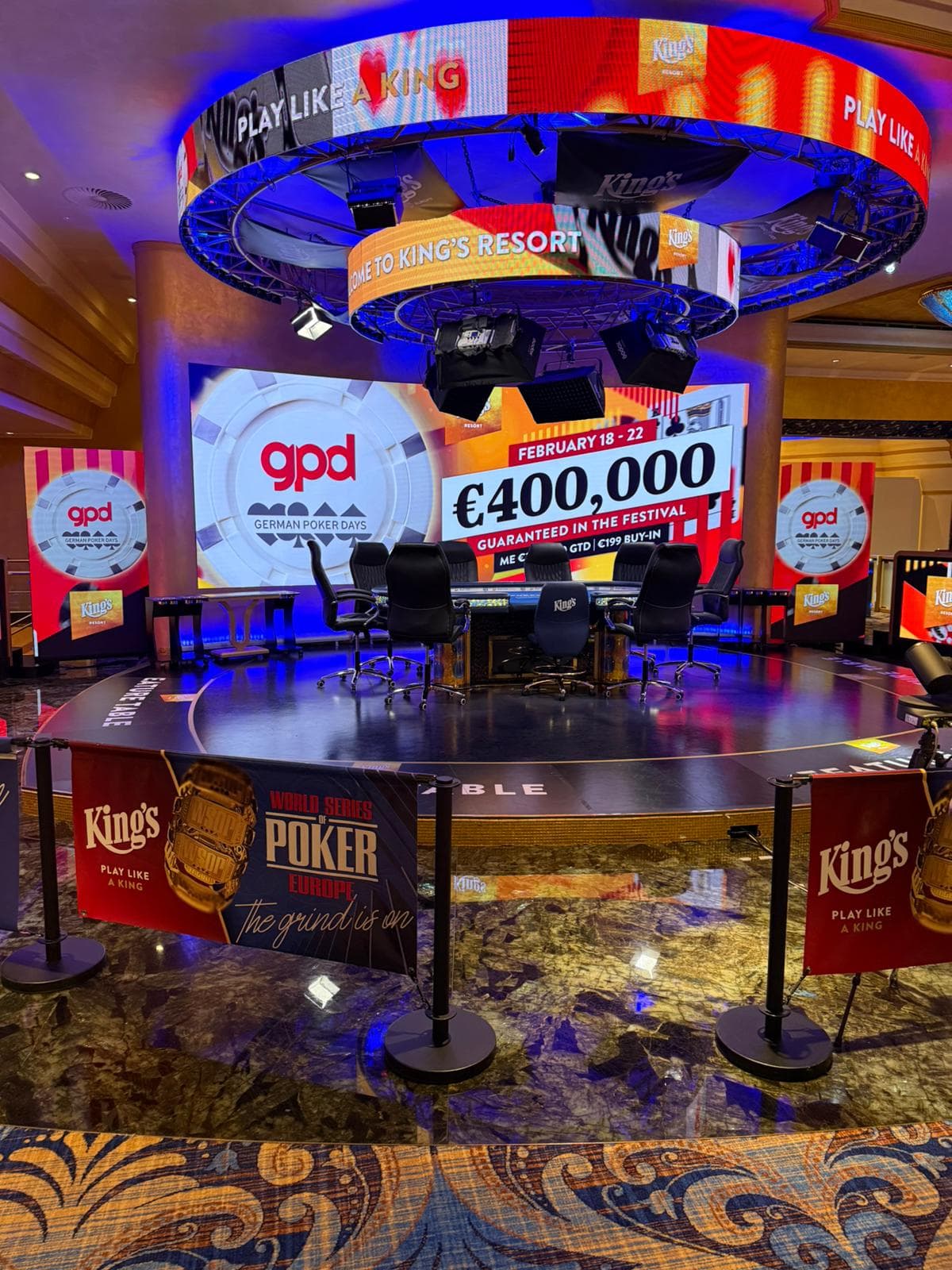 Der Feature Table im King's Resort Rozvadov auf einer Bühne, dahinter eine Leinwand der German Poker Days mit 400.000 Euro garantiertem Preispool.