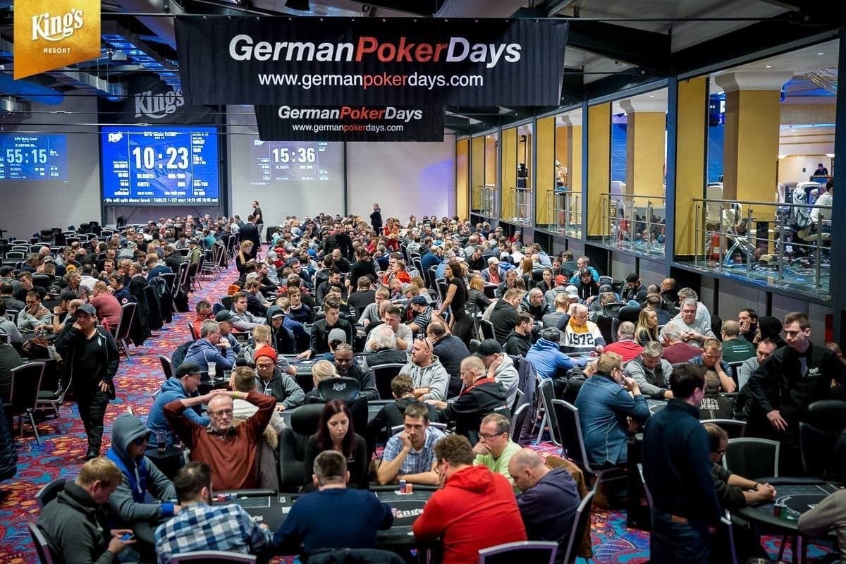 Voll besetzter Turniersaal im King's Resort Rozvadov, über den Pokertischen hängen Banner der German Poker Days.