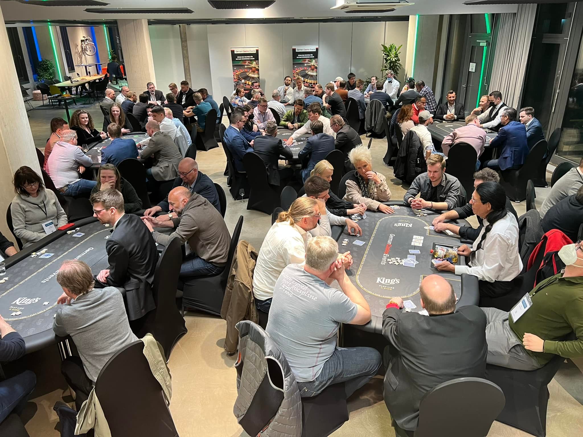 Blick über zahlreiche besetzte Pokertische in einem Turniersaal des King's Casino Rozvadov.