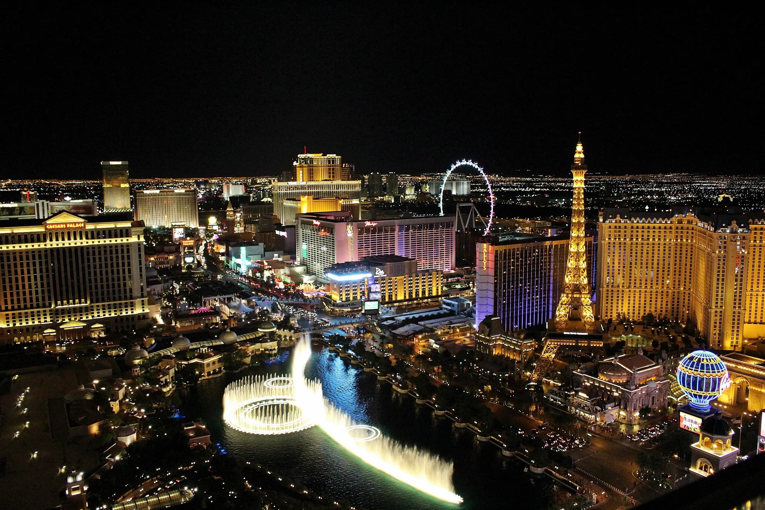 Der Las Vegas Strip bei Nacht aus der Luft, die großen Hotels sind hell beleuchtet.